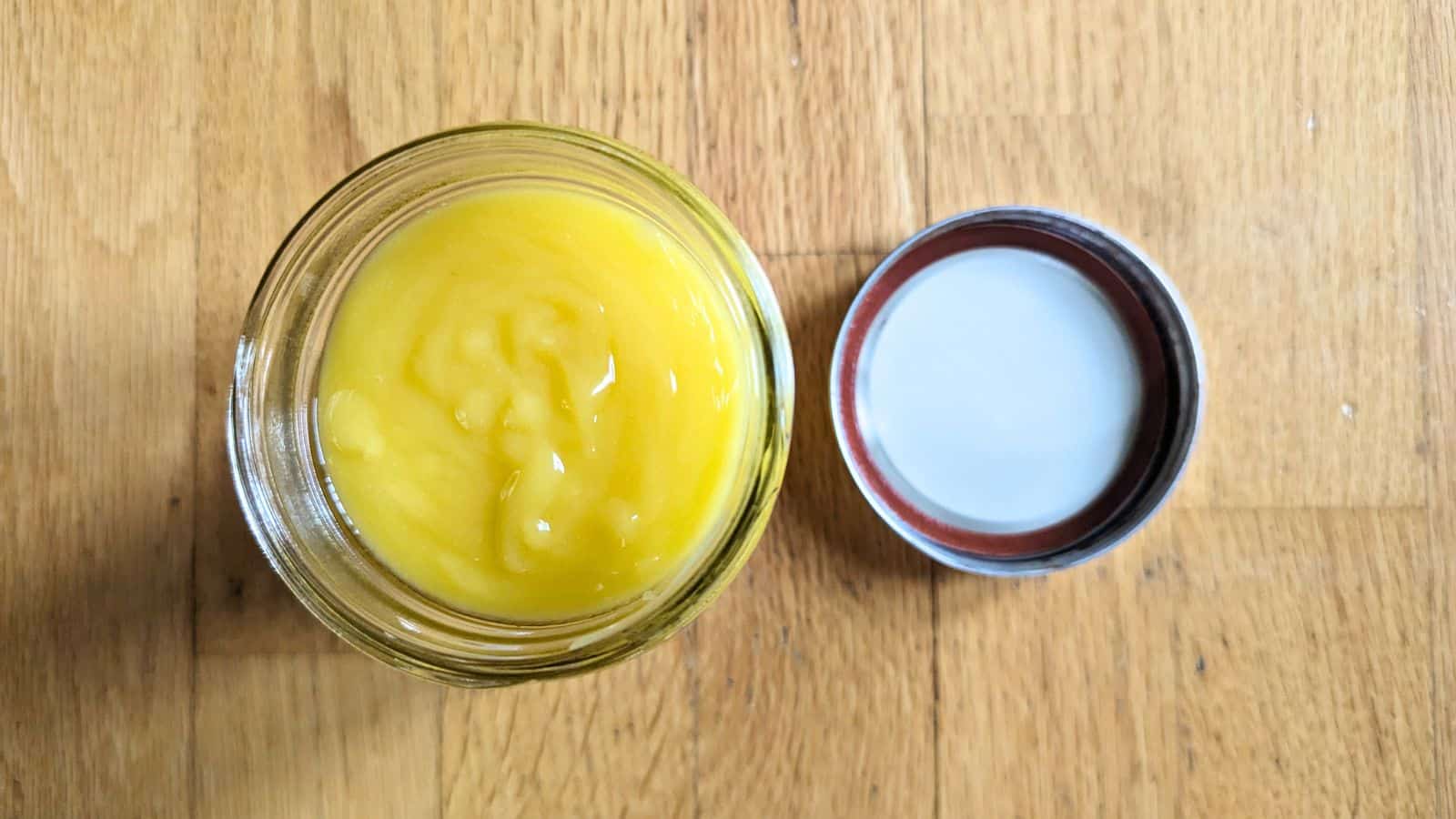 Image shows a spoon dipping into a jar of Lemon Curd.