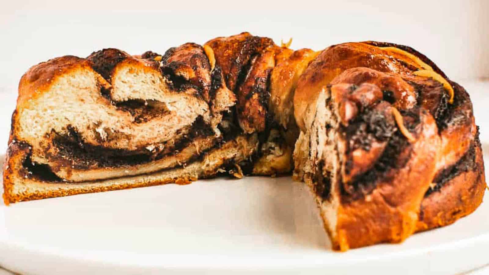 low angle shot of a chocolate babka with a wedge removed so you can see the inside.