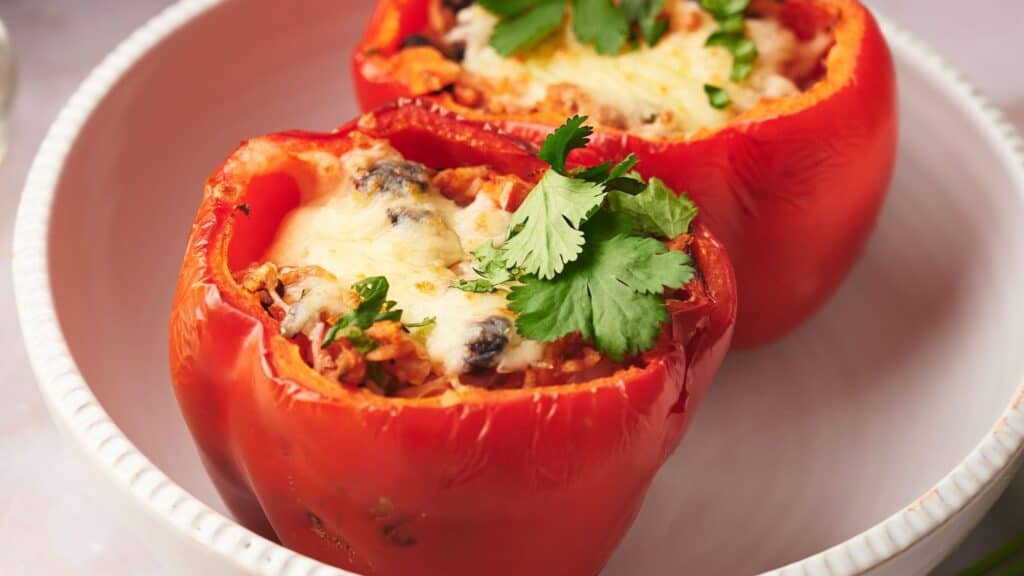 Two stuffed peppers on a white plate.