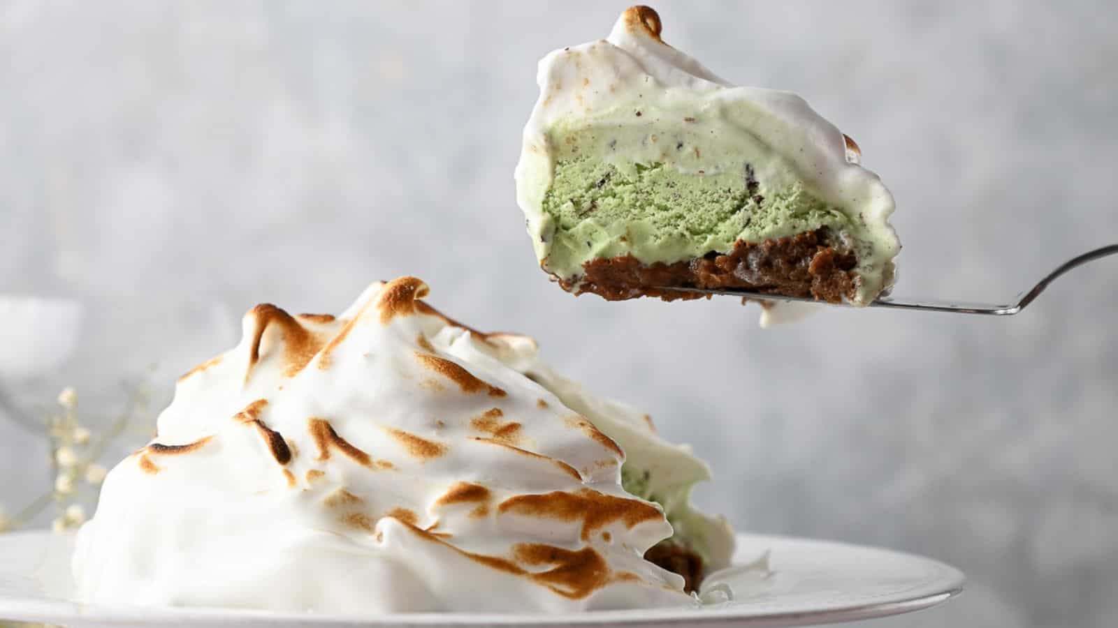 A slice of baked Alaska on a cake slice above the pie with a slice removed.