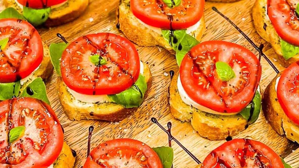 A tray of bruschetta with tomatoes and basil.