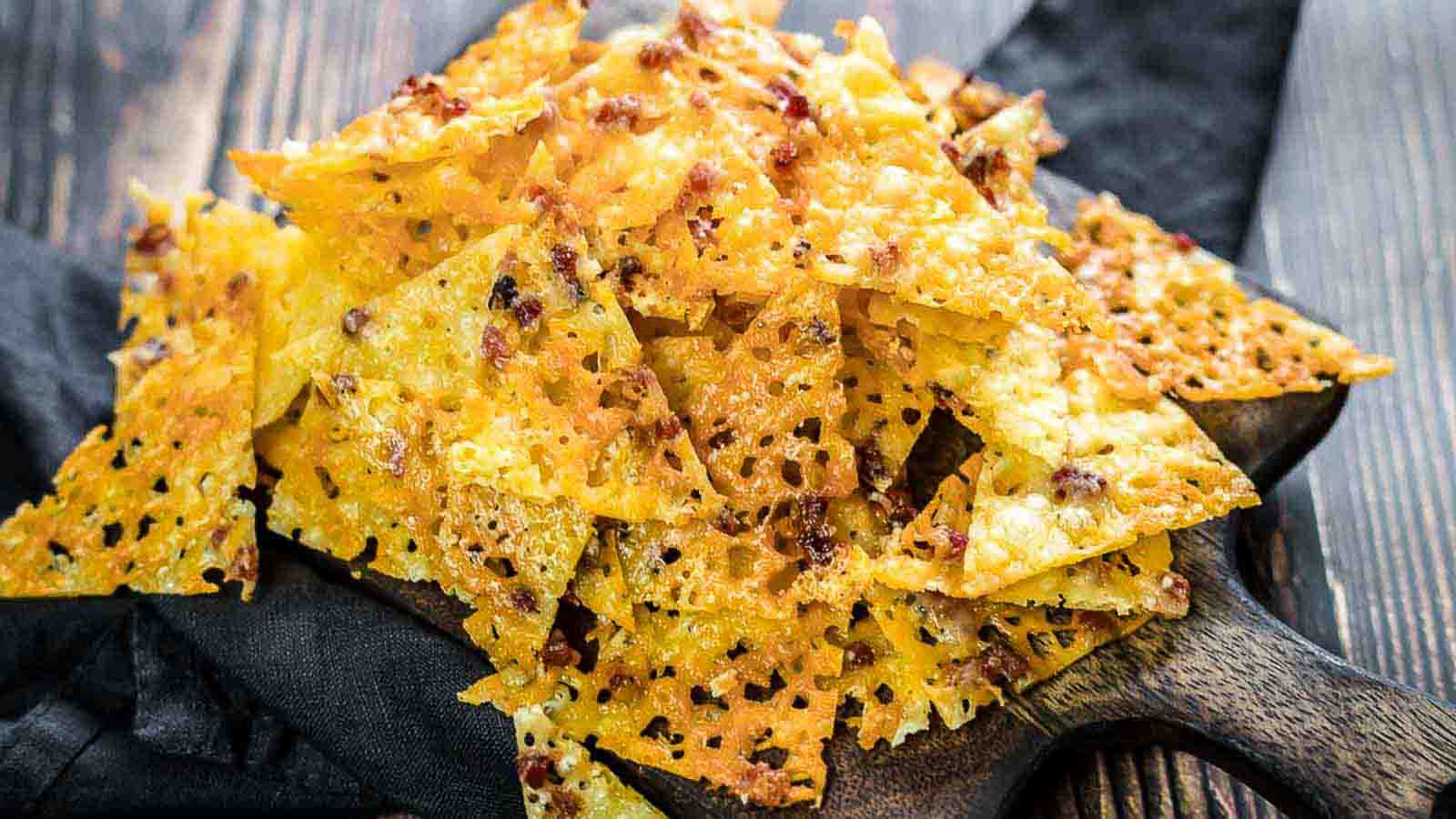 Cheese Bacon Nachos Chips on a dark napkin.