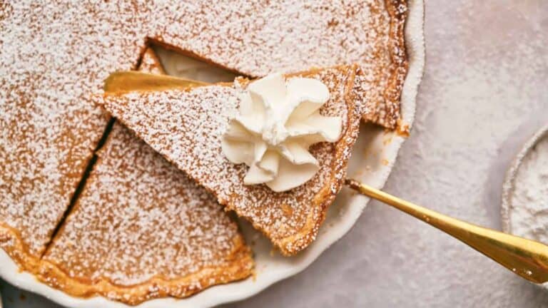 A slice of cinnamon pie on a cake slice over the remaining pie.