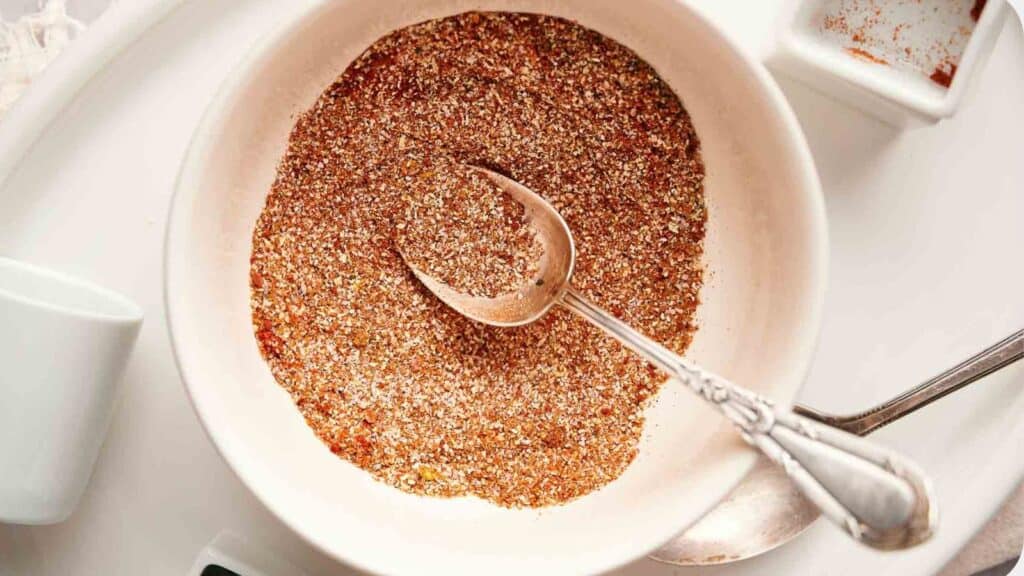 A bowl of brown sugar with a spoon next to it.