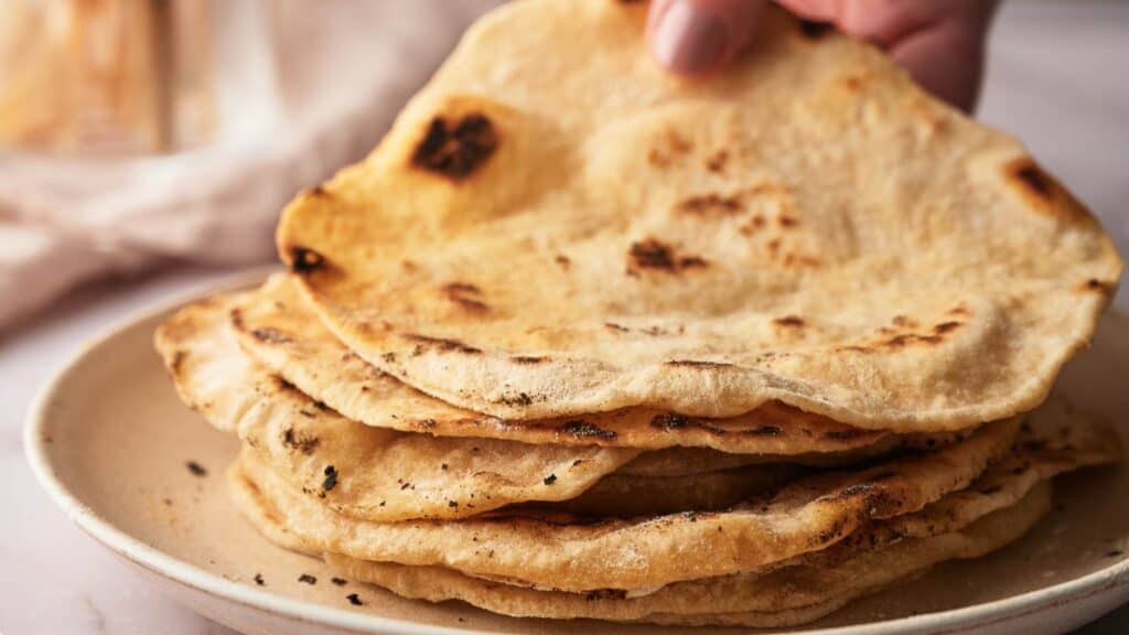 A stack of naan bread on a plate.