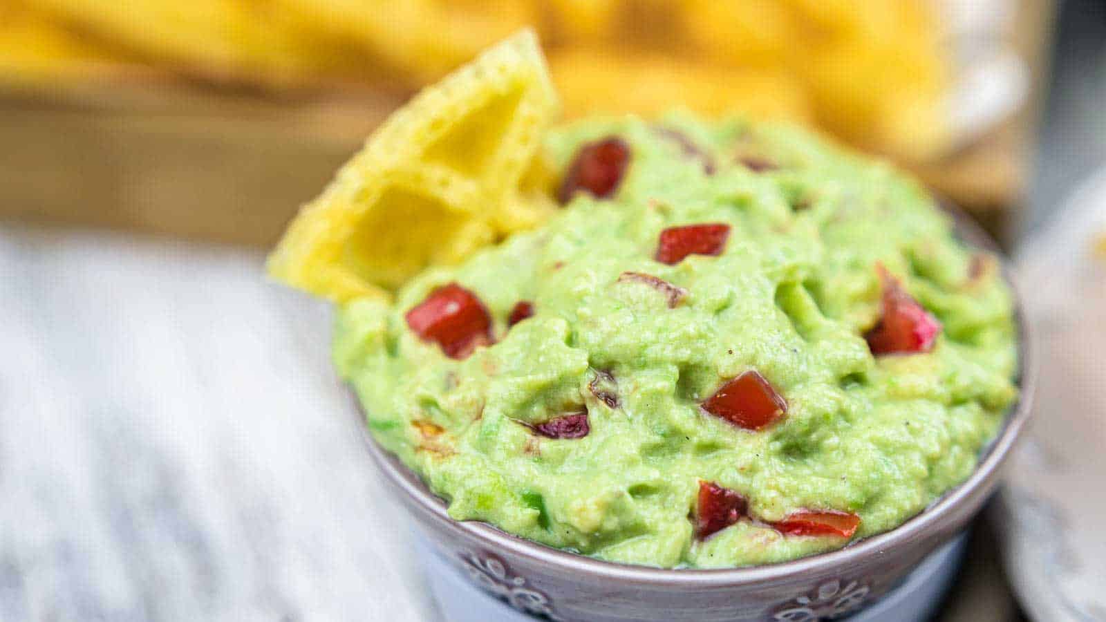 Guacamole Dip with Sour Cream in a bowls with chips.