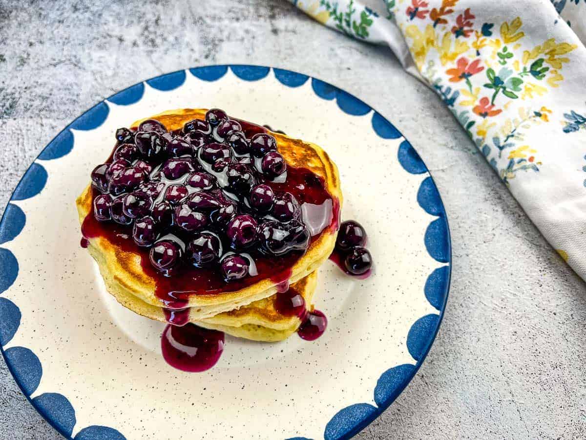 Buttermilk pancakes with blueberry sauce on a plate.