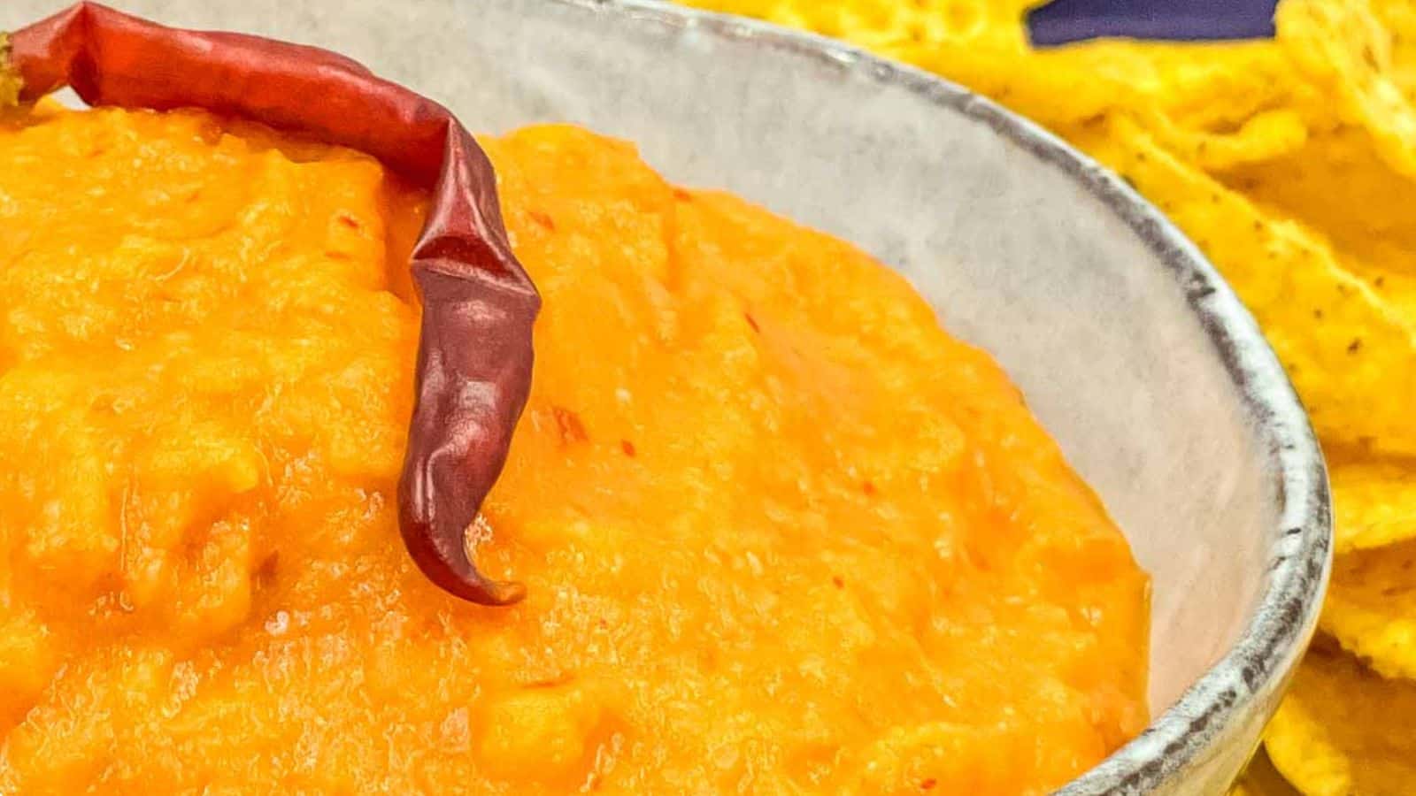 Salsa taquera in a serving bowl, with a large red chili on it.