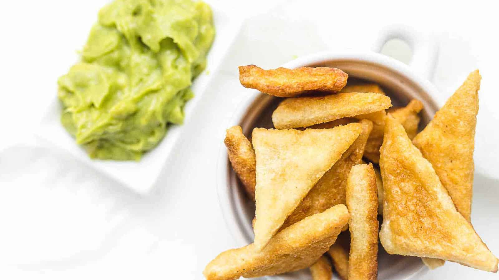Tortilla Chips with guacamole behind. 