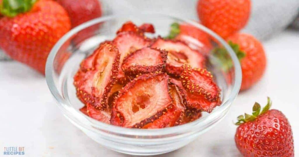 Sliced strawberries in a glass bowl.