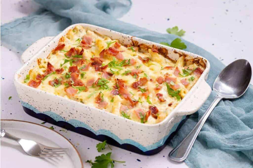 A casserole dish with bacon and cheese in it.