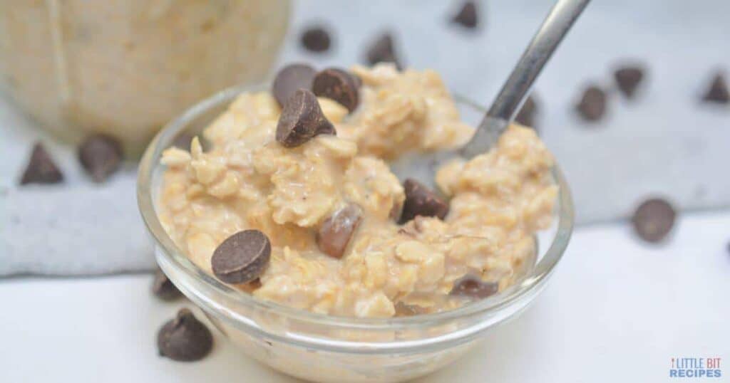 A bowl of oatmeal with chocolate chips and a spoon.