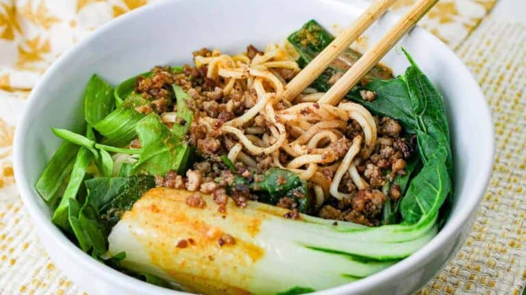 A bowl of asian noodle soup with chopsticks.