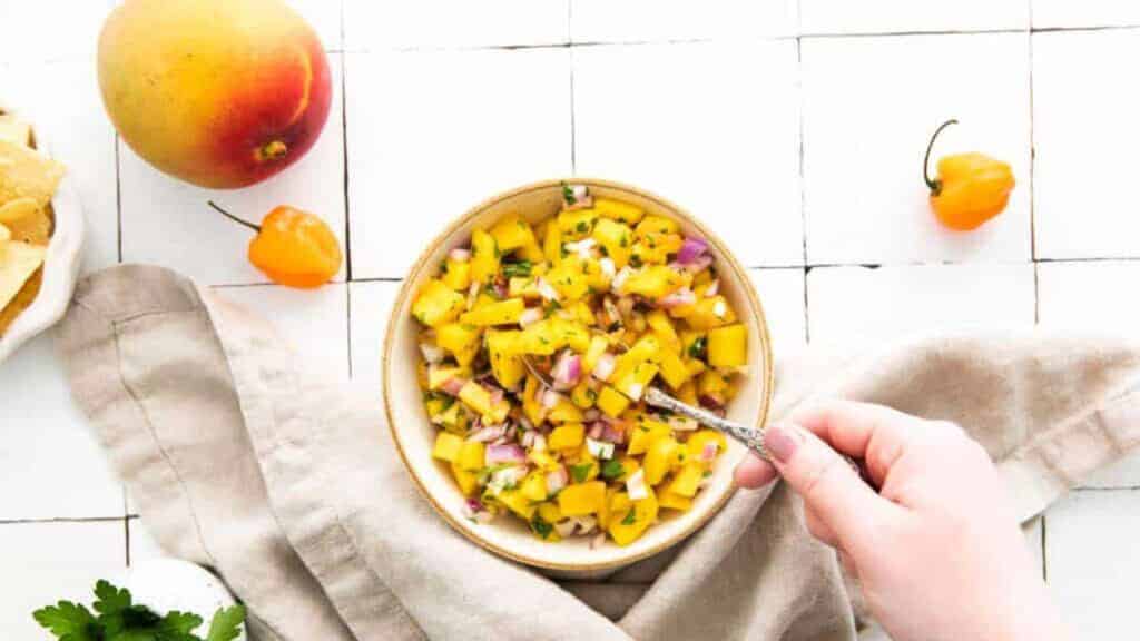 A bowl of mango salsa paired with tortilla chips for taco recipes.