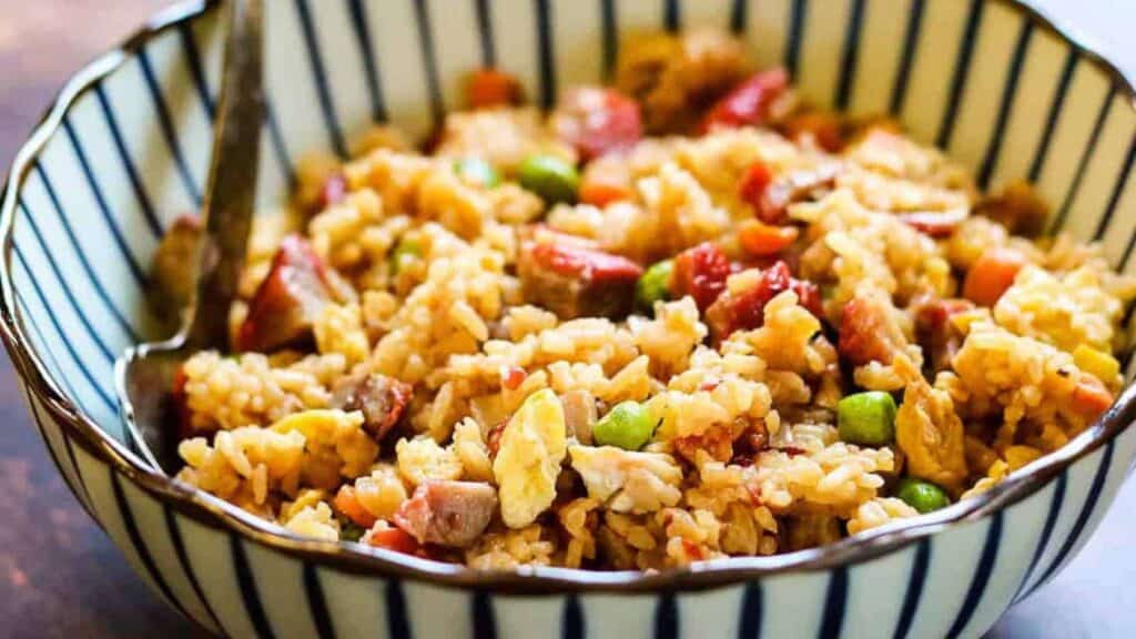 A bowl of fried rice with meat and vegetables.