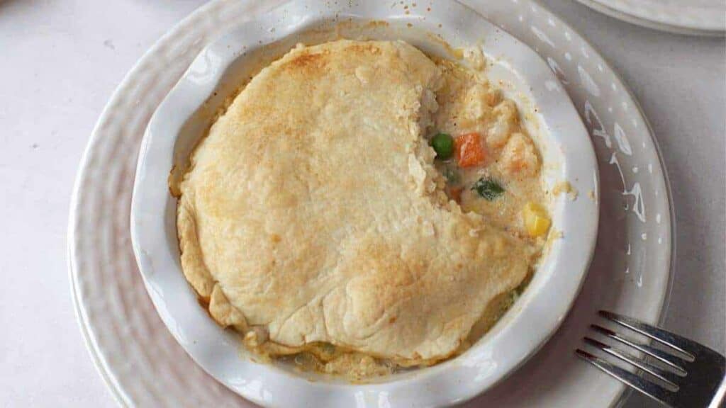 Chicken pot pie, a lunch idea worth taking a break for, served in a white dish with a fork.