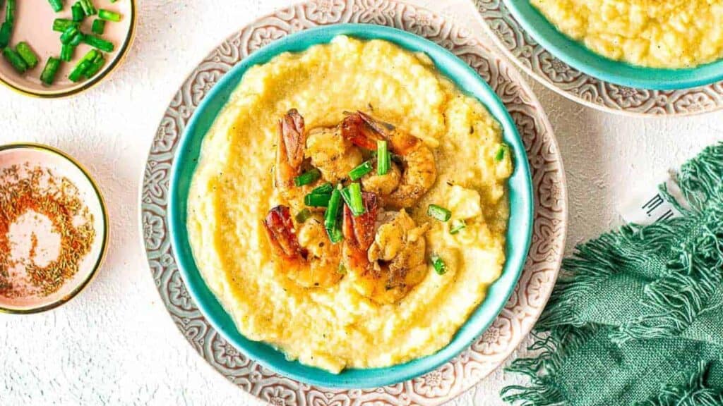 Two bowls of shrimp grits on a table.