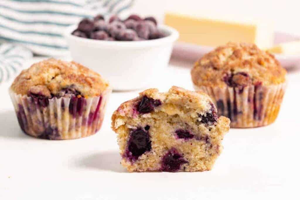 Blueberry muffins with a bite taken out.