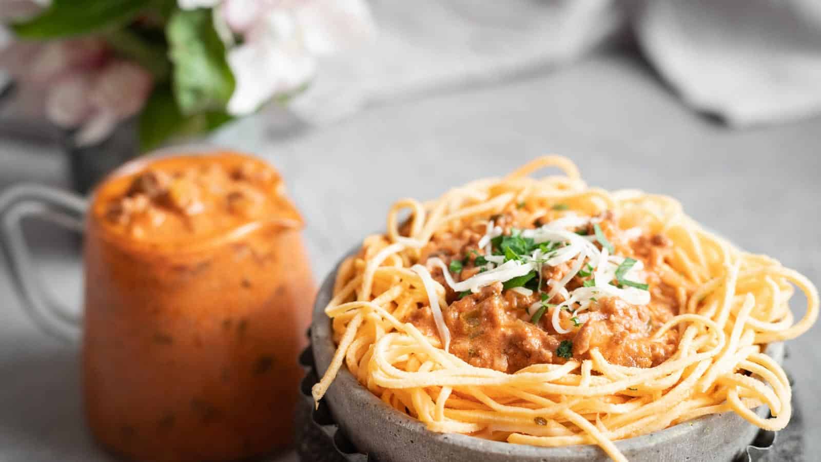 Low Carb Spaghetti Bolognese in a grey bowl with extra sauce on the side. 