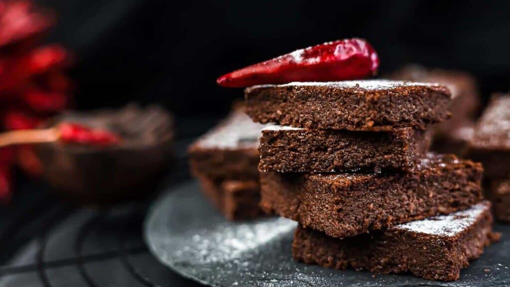 Best Fudgy Keto Brownies on top of each other with cupsicum on top.