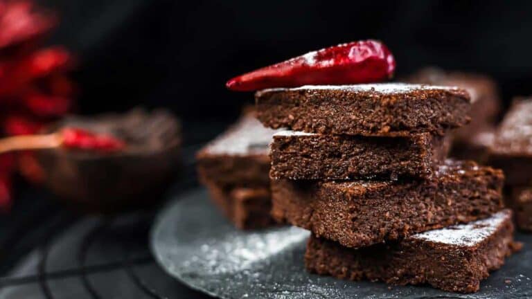 Best Fudgy Keto Brownies on top of each other with cupsicum on top.