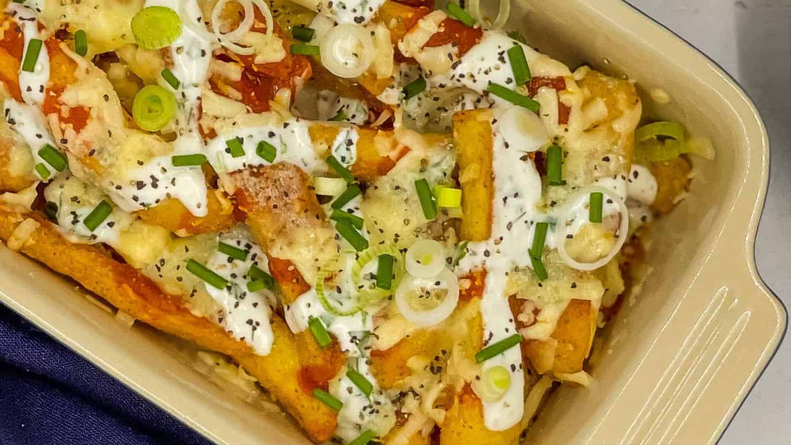 Buffalo Fries with ranch dressing on top in a casserole dish.