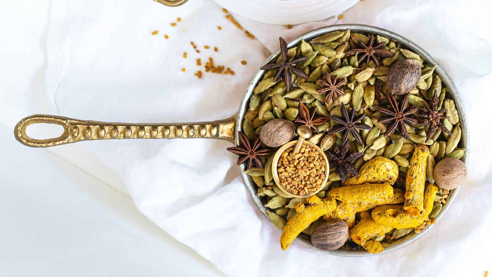 Whole spices inside a golden bowl. 