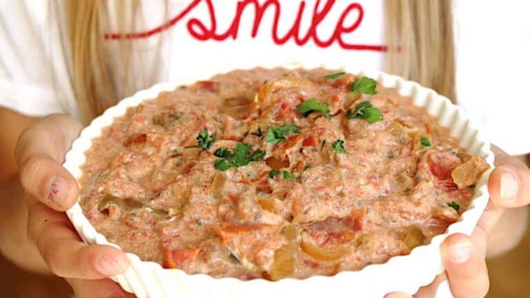 A girl holding a big casserole filled with vegetable stew.