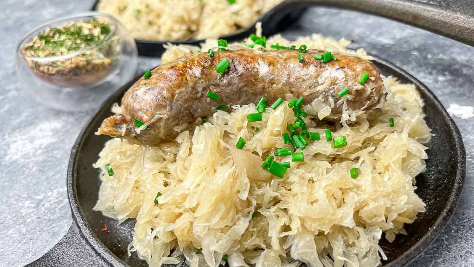 Baked Sausage and Sauerkraut on a cast iron plate. 