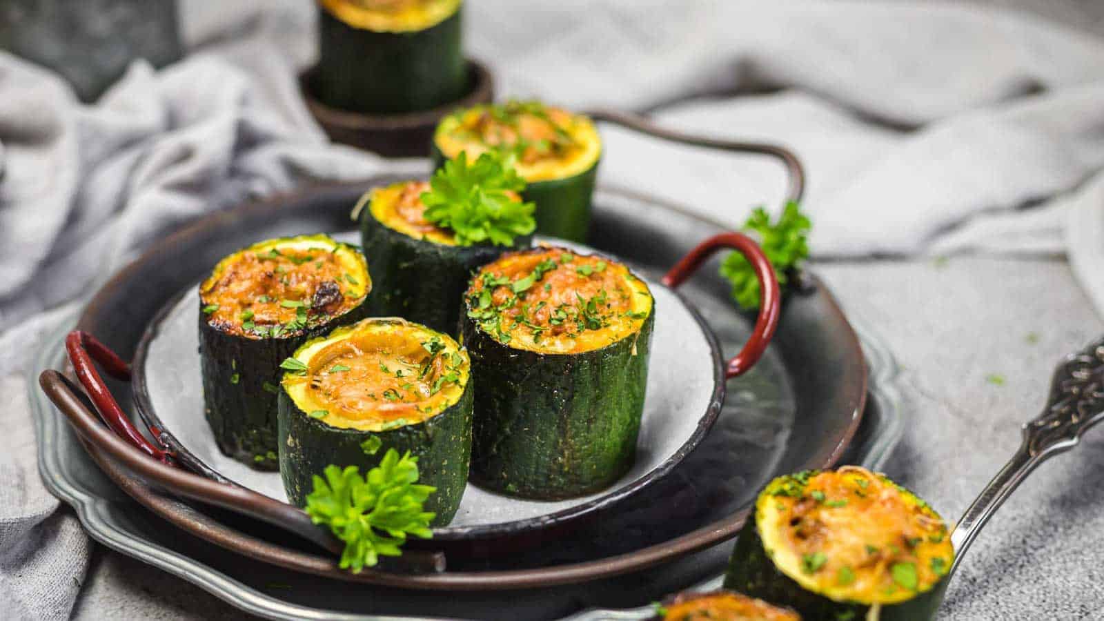 Stuffed Zucchini Mini Bites on a plate with herbs. 