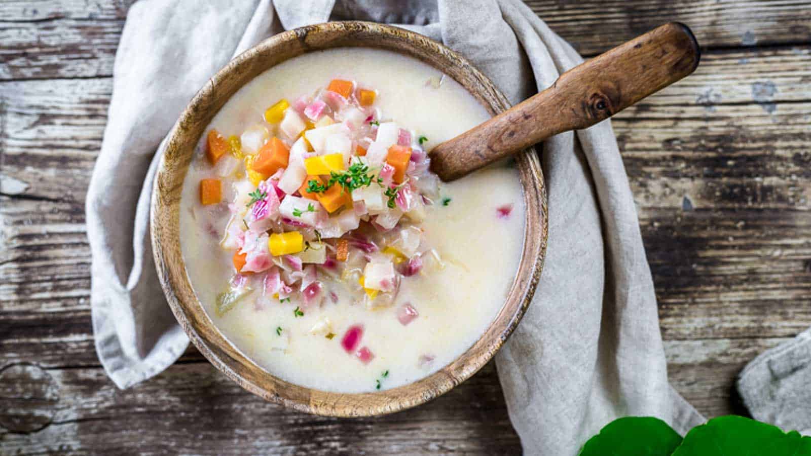 Winter Root Vegetable Soup inside wooden bowl with wooden spoon. 