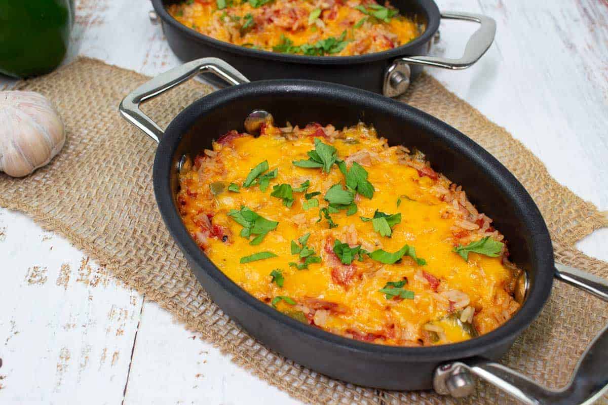 Baked Spanish Rice in two black baking dishes.