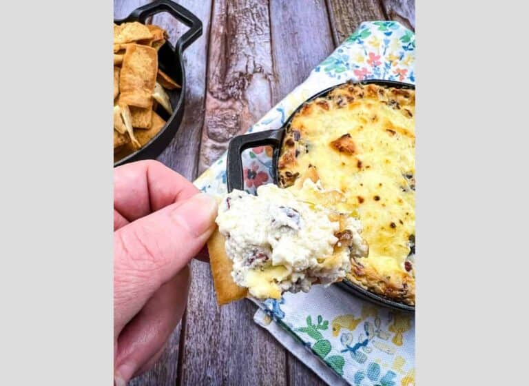 Beef jerky dip on a cracker held in a hand.