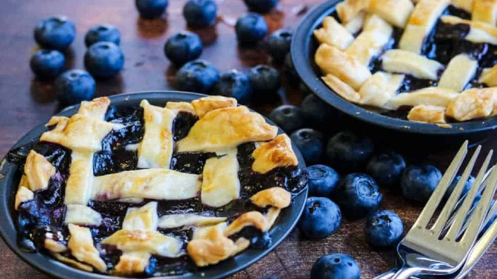 Mini blueberry pies in tins.
