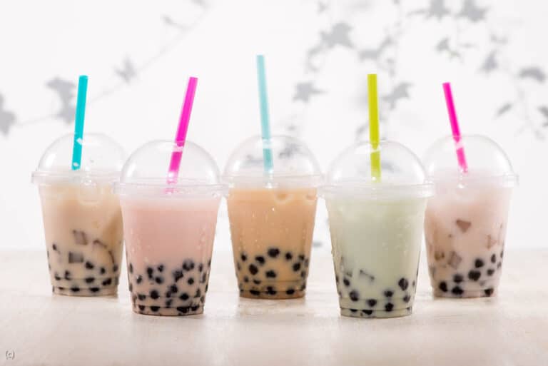 Five different types of bubble tea are lined up on a table.
