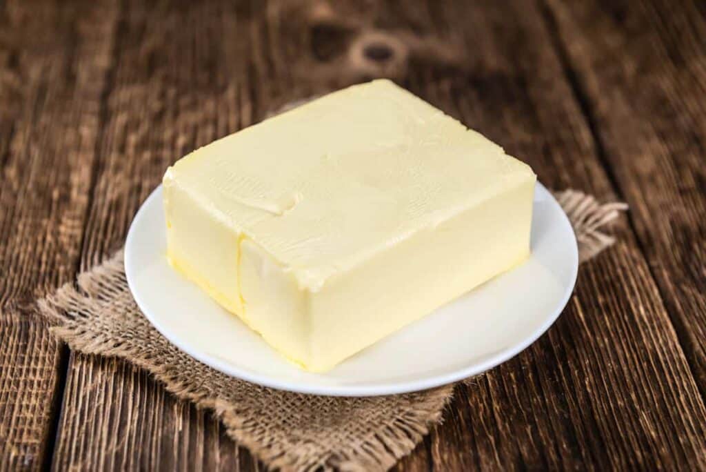 Butter on a plate on a wooden table.