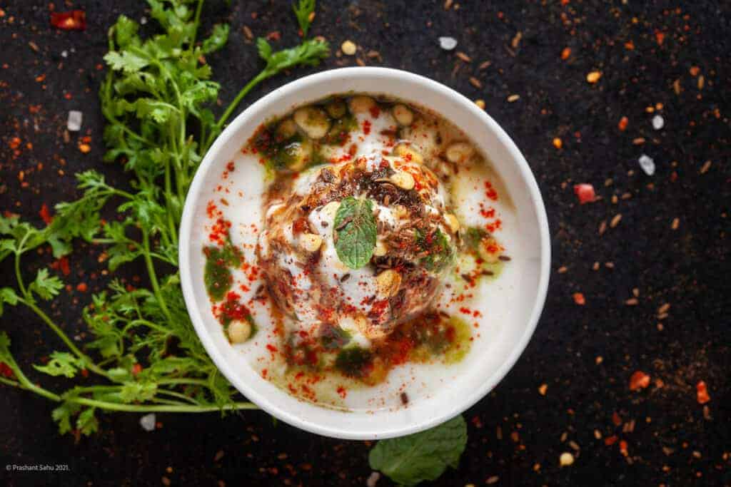 A bowl of yoghurt with herbs and spices.
