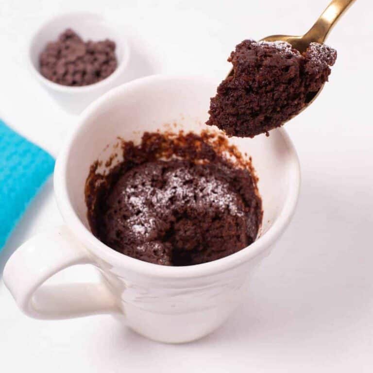 Chocolate mug cake with spoon bite.