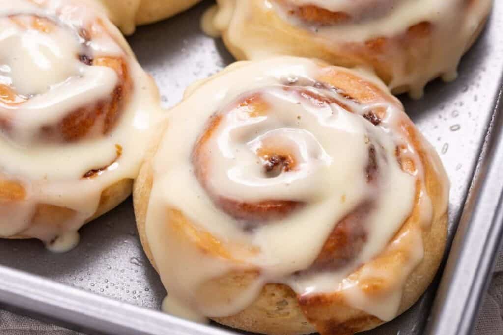 Cinnamon rolls in a pan with icing.