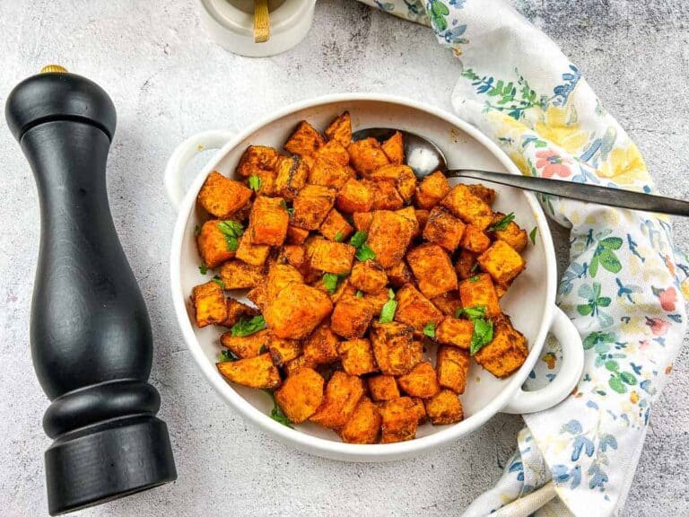 Sweet potato cubes on a plate with a dipping sauce.