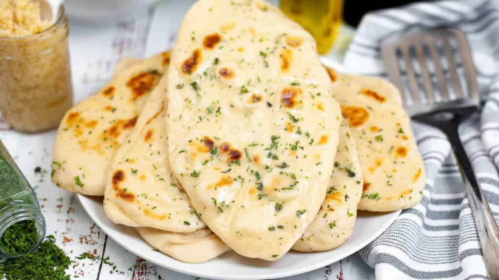 Naan bread on a plate with herbs and spices.