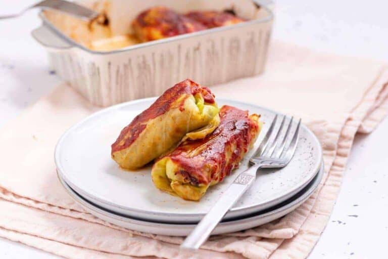 Two cabbage rolls on a plate with fork.