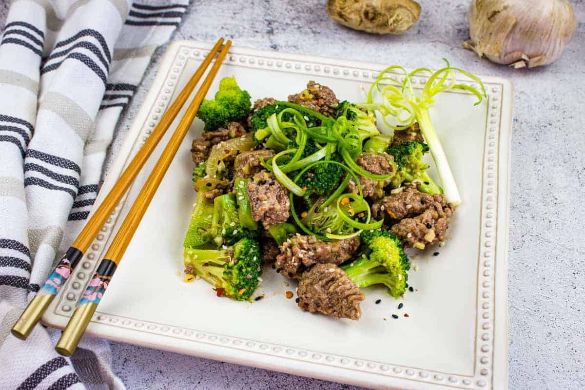 A plate of Ground Beef & Broccoli with chopsticks.