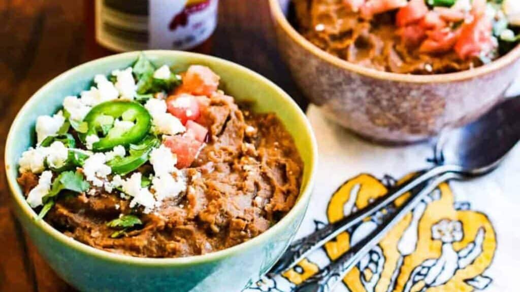 Two bowls of Mexican refried beans.