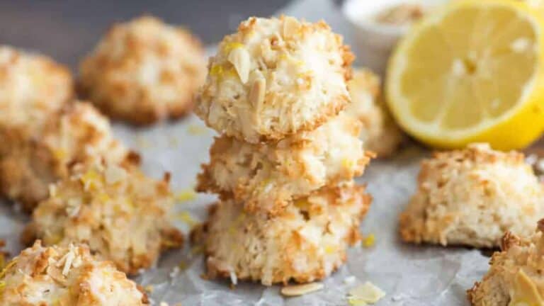 Low angle shot of lemon coconut macaroons on a parchment paper lined baking sheet.