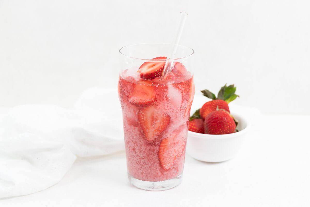 A glass of copycat Starbucks pink drink with a straw.