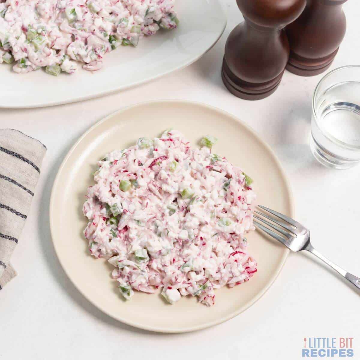 Easy Radish Salad on plate with glass of water.
