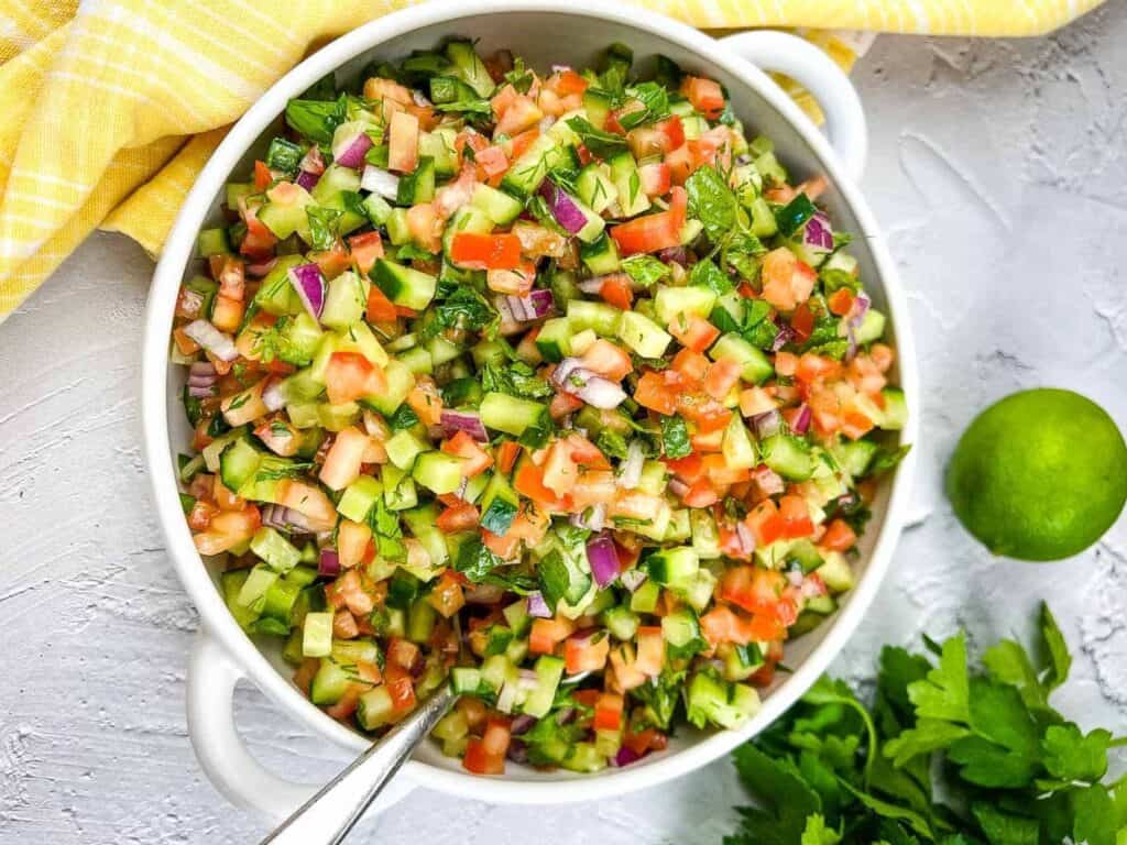 A bowl of shrimp and vegetable salad with a spoon.