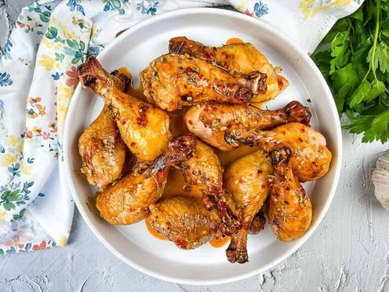 Smoked Chicken Legs with Red Pepper Glaze on a round platter.