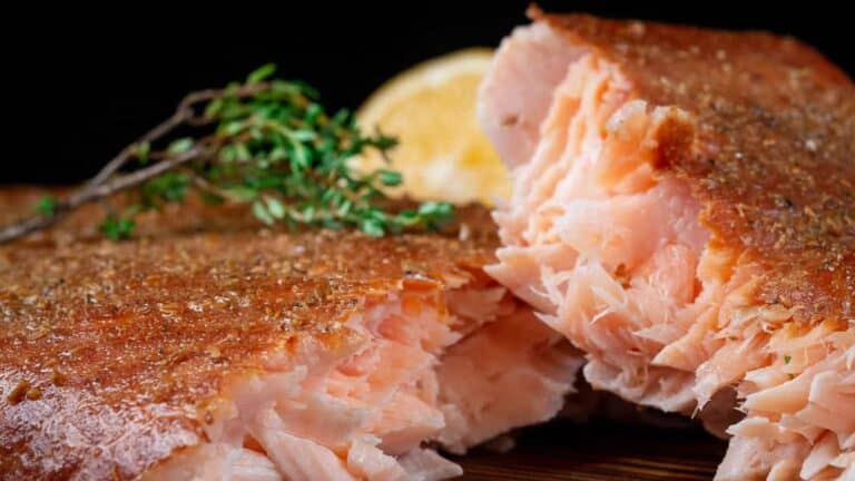 Flaky smoked salmon on a wooden board.